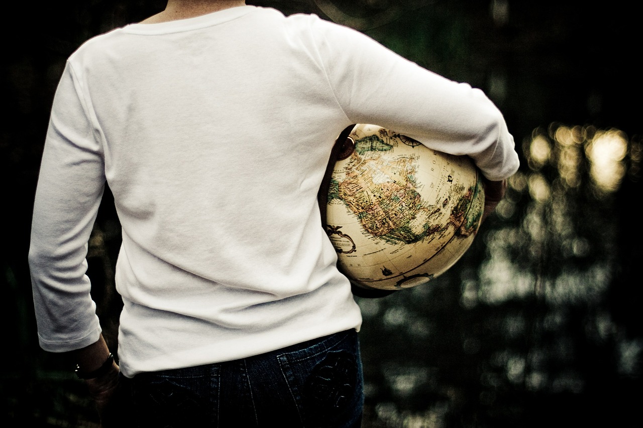 Ein Mensch hält einen Globus im Arm. Ein nachhaltiges Leben schützt die Erde.